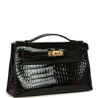 Black glossy crocodile skin handbag with gold turn-lock clasp and curved handle