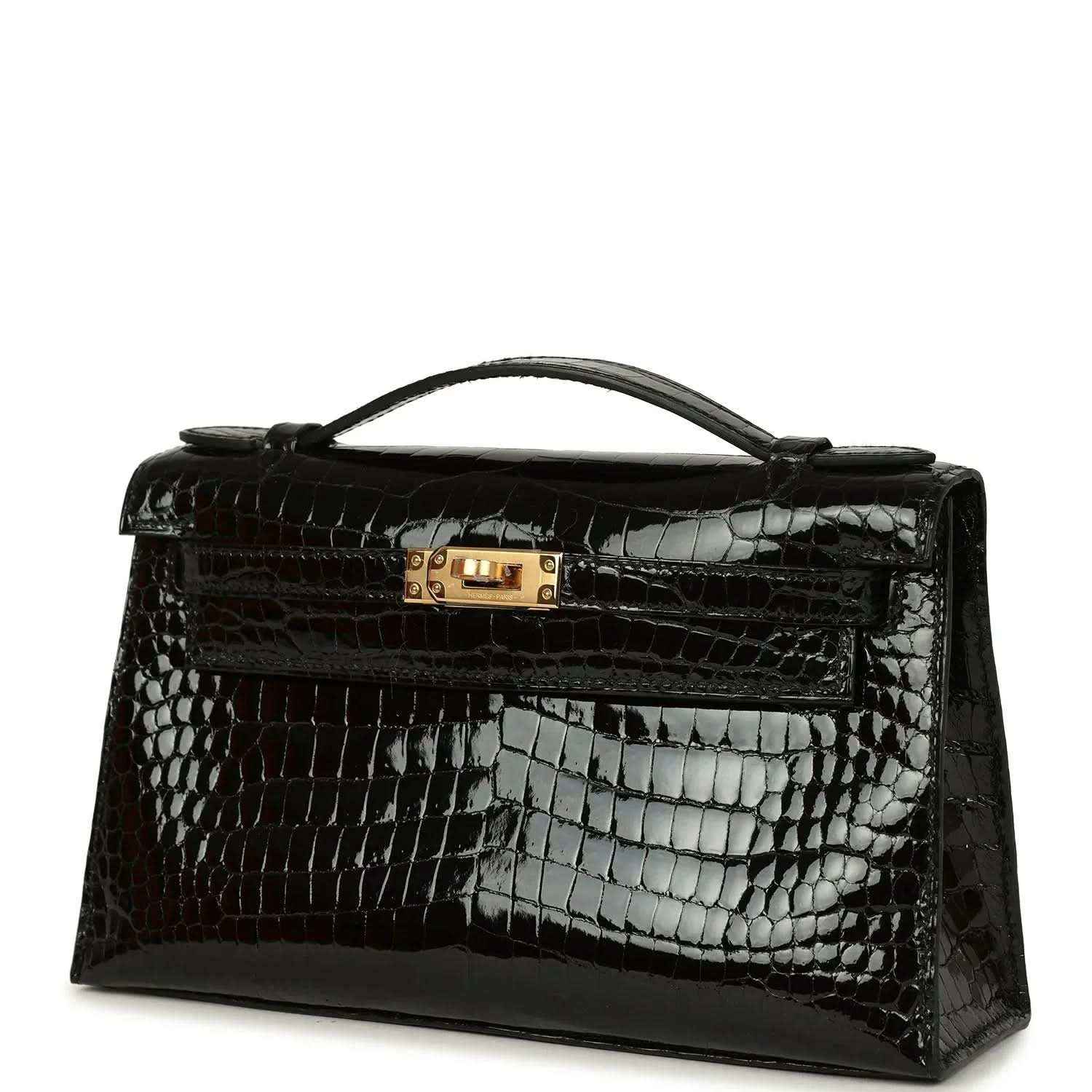 Black crocodile skin handbag with gold clasp, top handle, and embossed shine