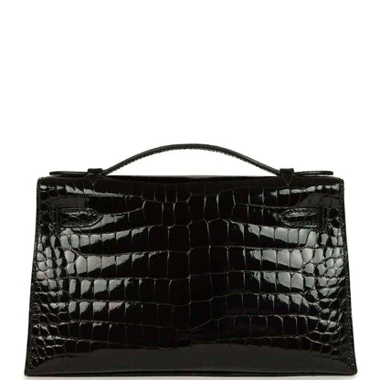 Black shiny crocodile skin handbag with top handle and gold front clasp detail