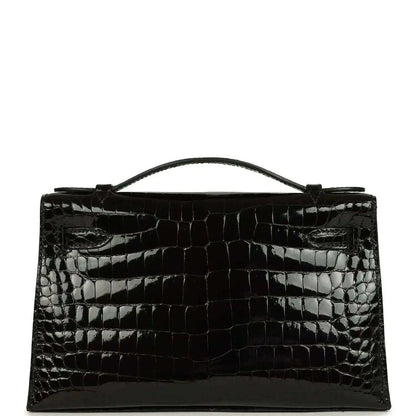 Black shiny crocodile skin handbag with top handle and gold front clasp detail