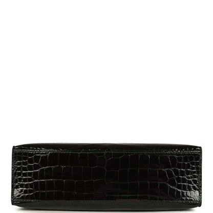 Black crocodile skin wristlet with smooth bottom edge and sleek strap