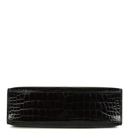 Black crocodile skin wristlet with smooth bottom edge and sleek strap