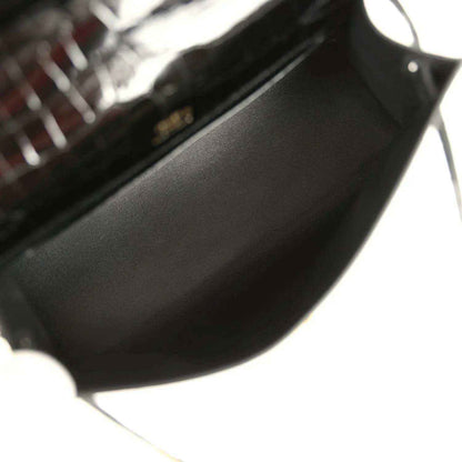 Black leather-lined interior of crocodile handbag with gold hardware corner