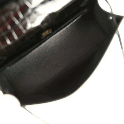 Black leather-lined interior of crocodile handbag with gold hardware corner