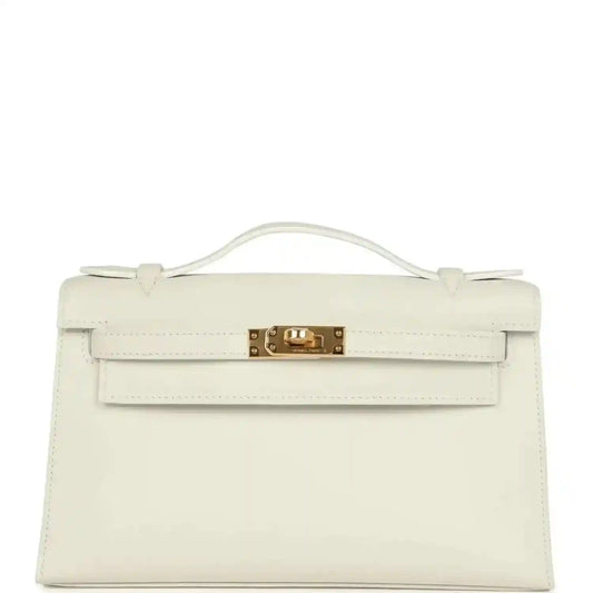 White leather clutch bag with top handle, front flap, and gold turn-lock clasp