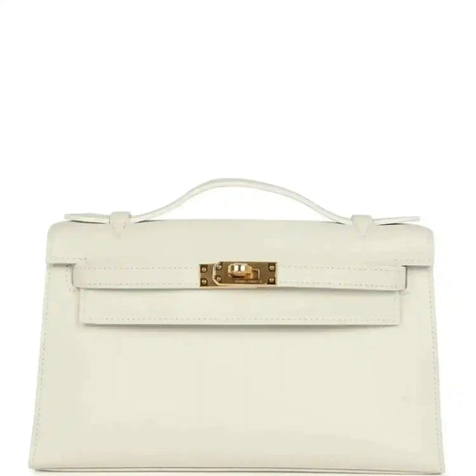 White leather clutch bag with top handle, front flap, and gold turn-lock clasp