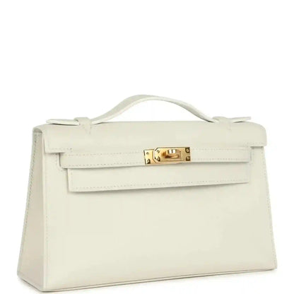 White leather clutch bag with handle, front flap detail, and gold turn-lock clasp
