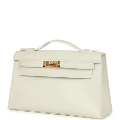 White leather clutch bag with front flap, top handle, and gold turn-lock clasp