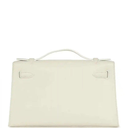 White leather clutch bag with top handle and front flap, viewed from back
