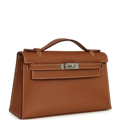 Brown leather top-handle clutch with front flap and silver-toned lock