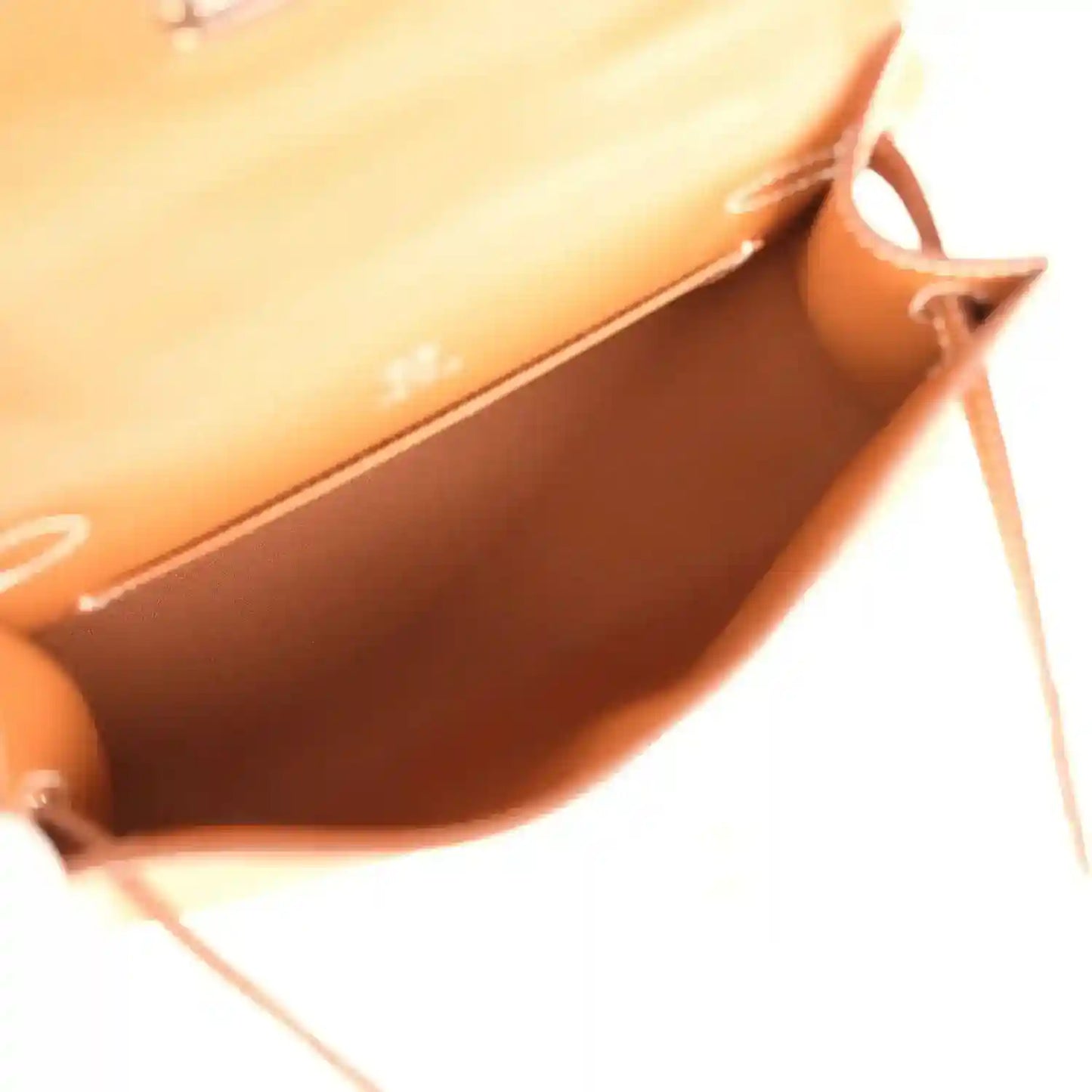 Brown leather clutch interior view with side strap loop and stitching