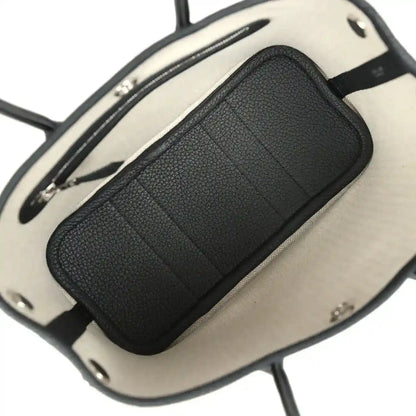Tote bag interior with beige lining and black leather pocket panel