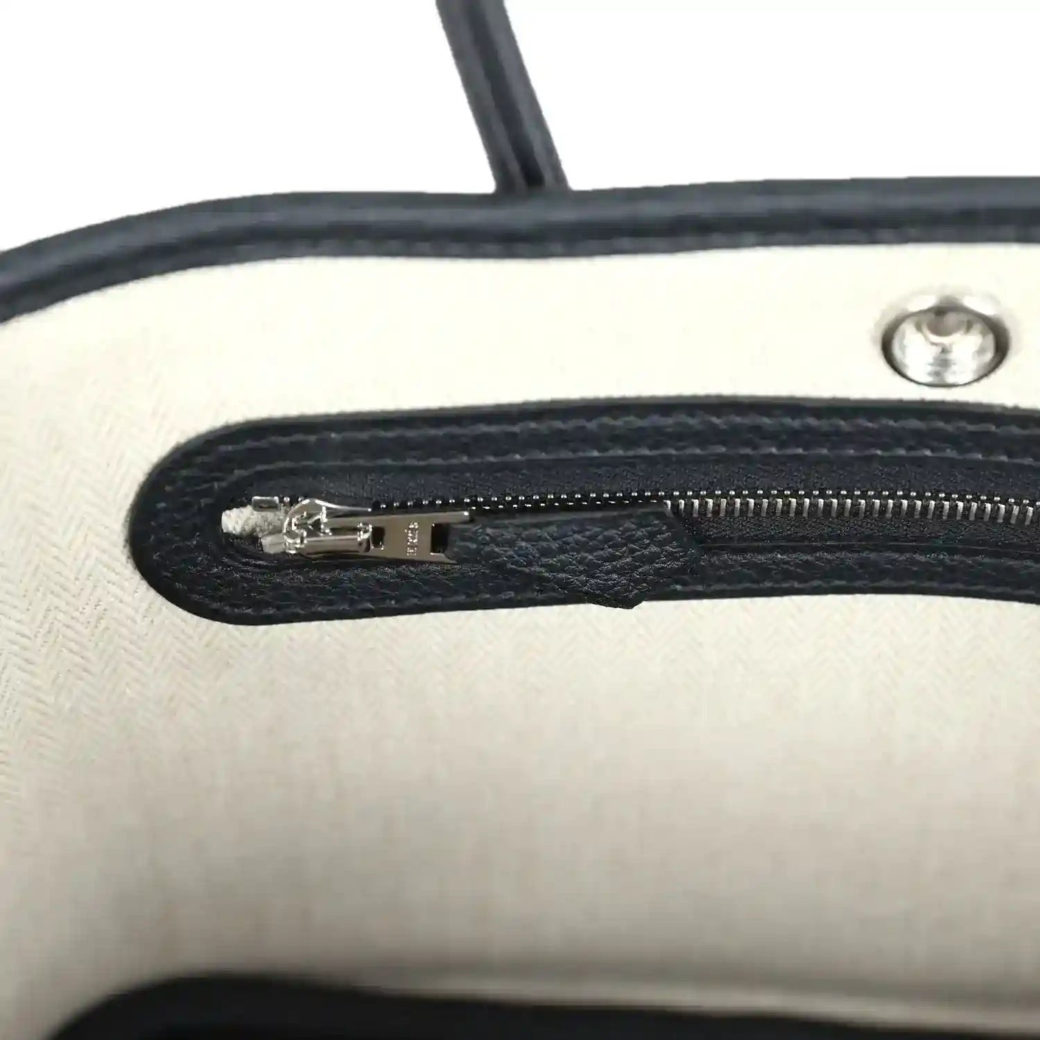 Tote bag interior zip pocket with silver zipper pull and black lining