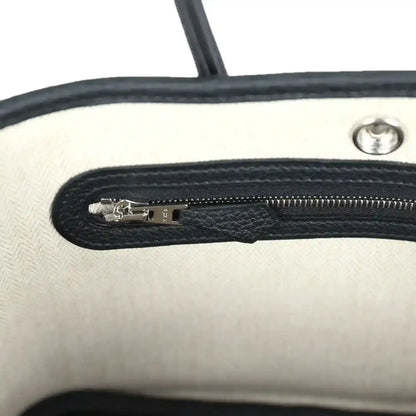 Tote bag interior zip pocket with silver zipper pull and black lining