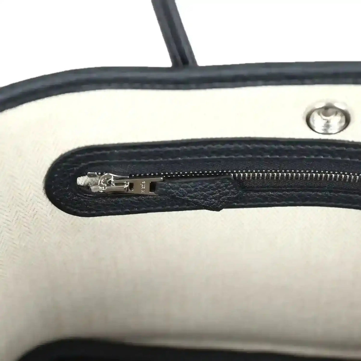 Tote bag interior zip pocket with silver zipper pull and black lining