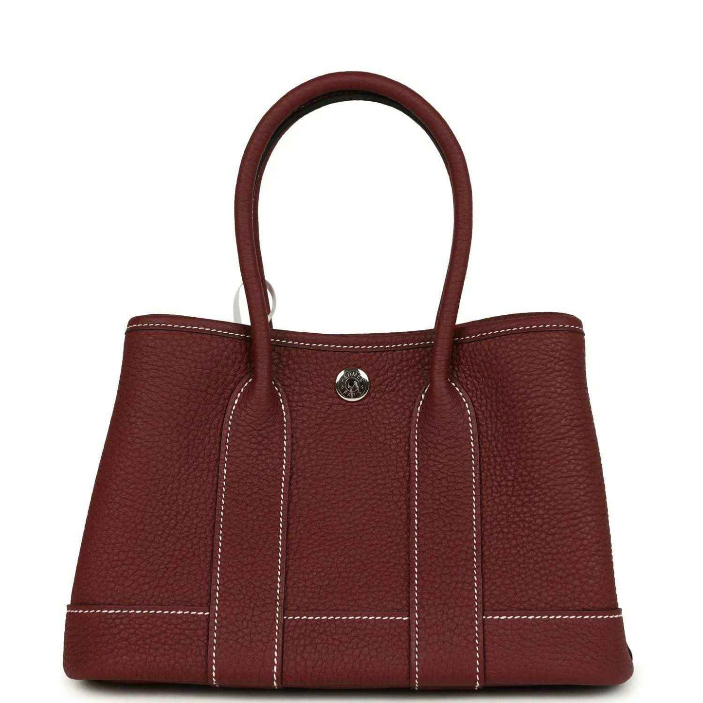 Red leather tote bag with top handles, front snap button and stitched panels.