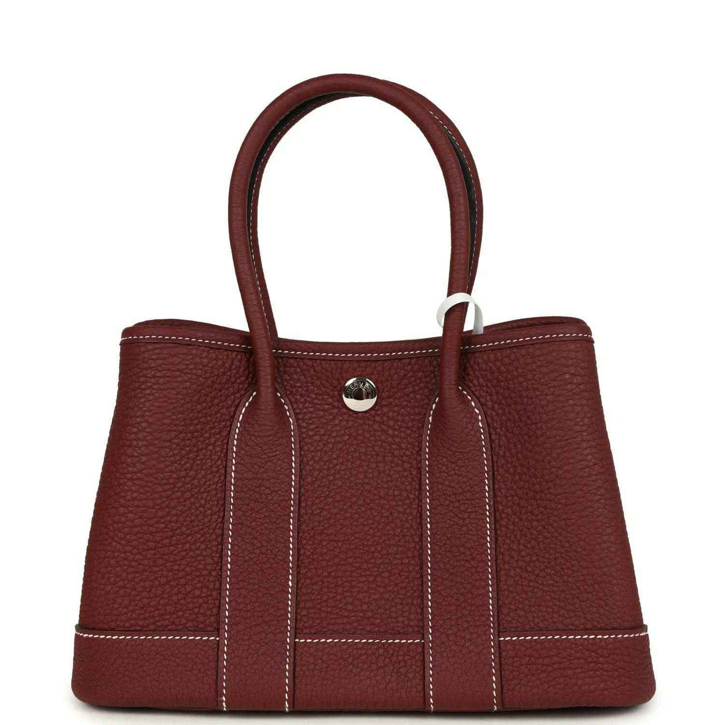 Red leather tote bag with top handles, front snap button, and stitched front panels.
