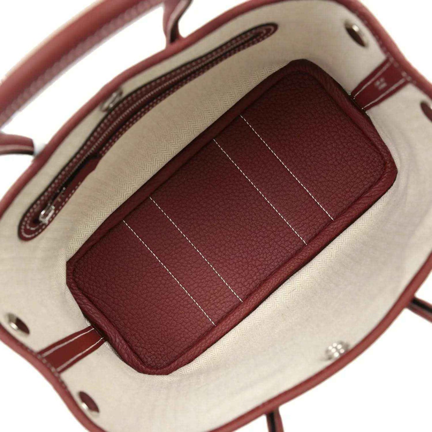 Canvas-lined tote interior with burgundy zip pocket and stitched divider lines.