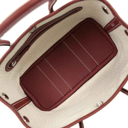 Canvas-lined tote interior with burgundy zip pocket and stitched divider lines.