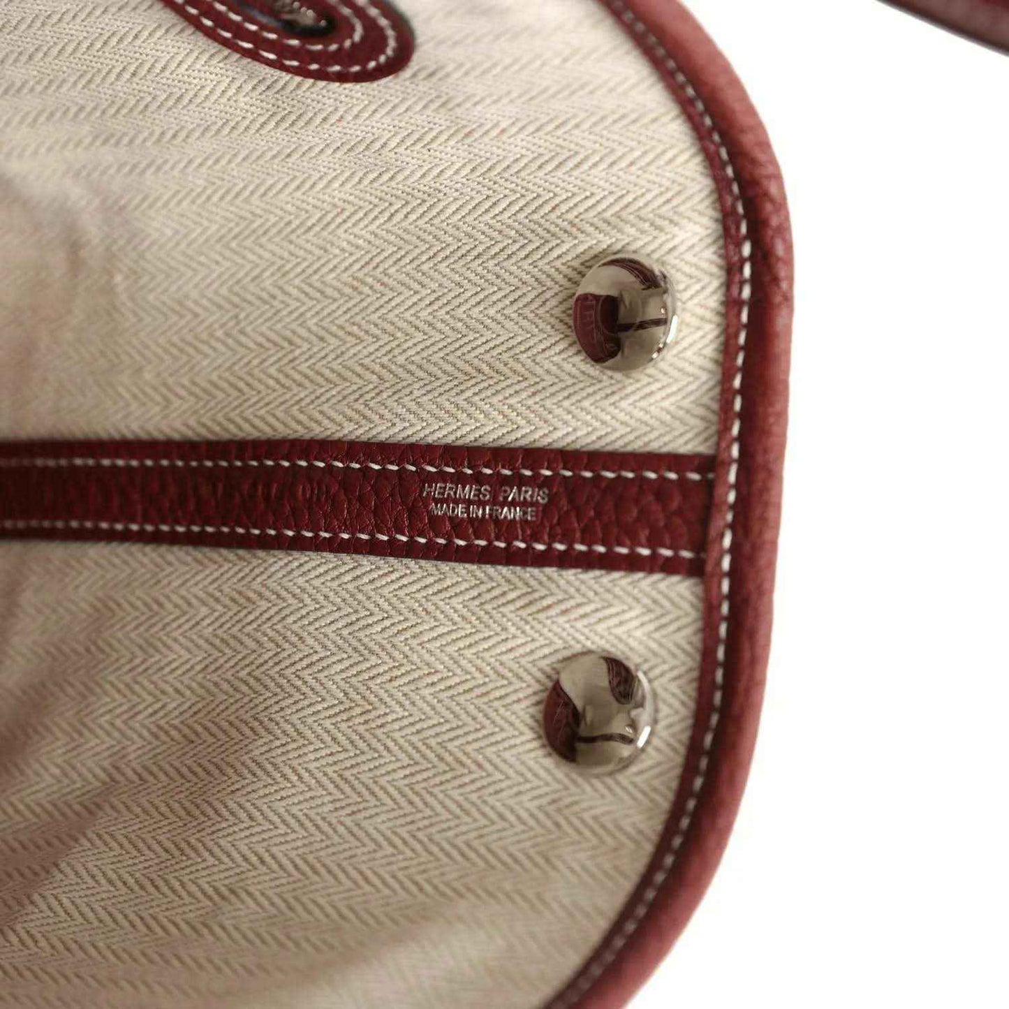 Canvas tote lining with HERMES PARIS logo and burgundy leather corner snap.