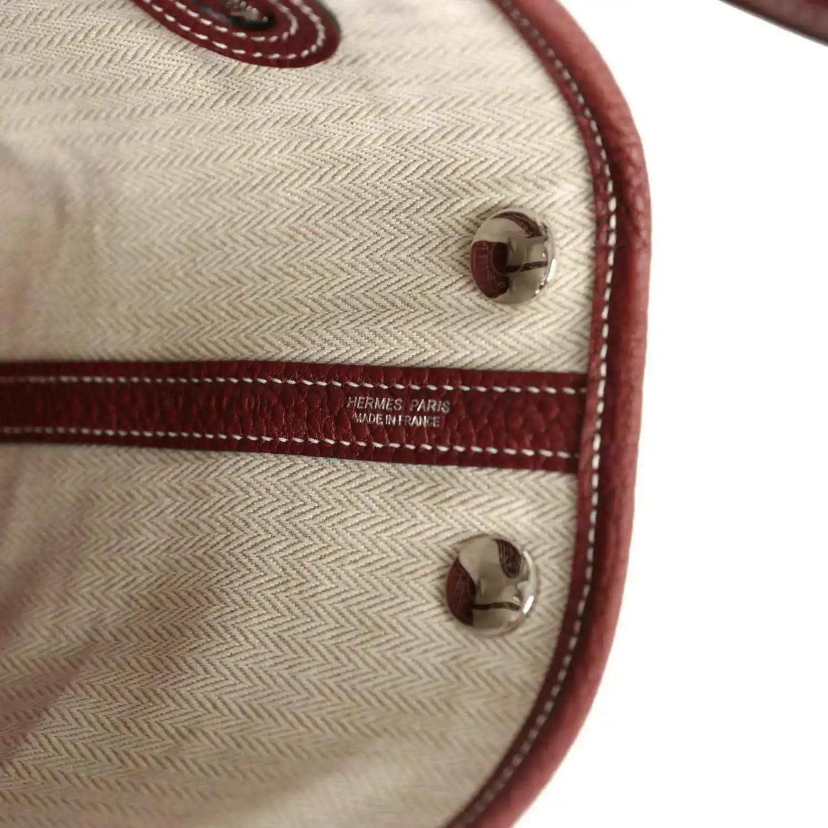 Canvas tote lining with HERMES PARIS logo and burgundy leather corner snap.