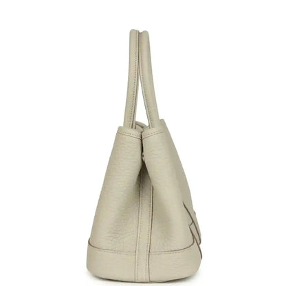 Hermes Garden Party Neo 23 tote bag side view in light beige leather with short handles and curved base
