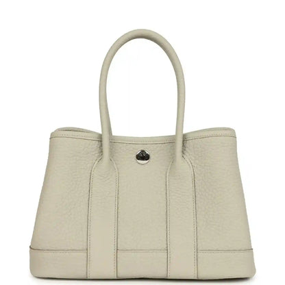 Hermes Garden Party Neo 23 tote bag front view in light beige leather with round front clasp