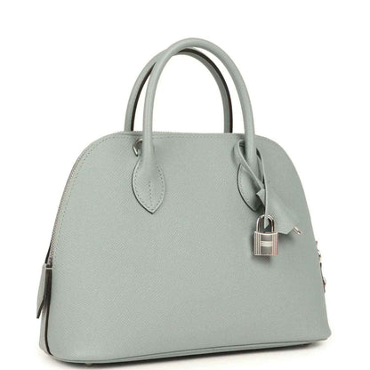Light gray leather handbag with top handles and silver-tone lock detail, side view