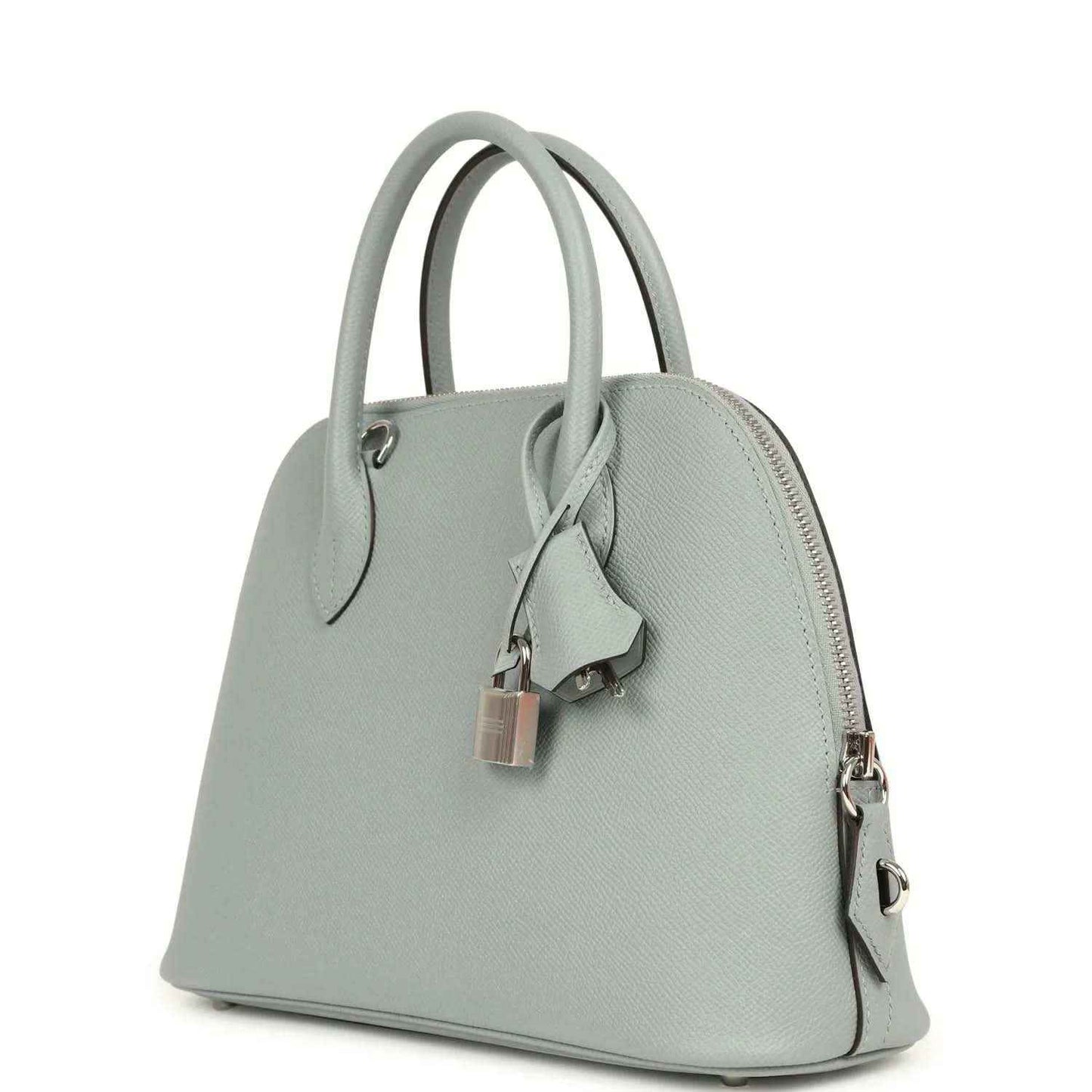 Light gray leather handbag angled side view with zipper pocket and silver-tone zipper pulls