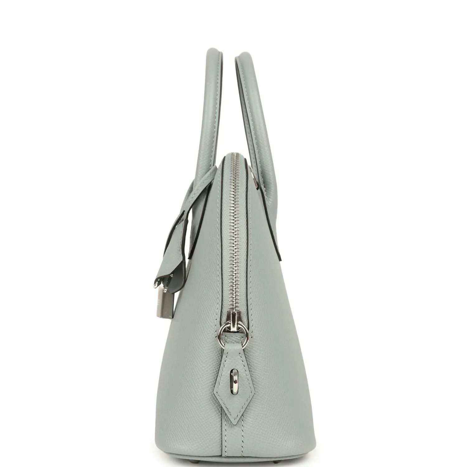 Light gray leather handbag side profile with zipper closure and hanging charm tab