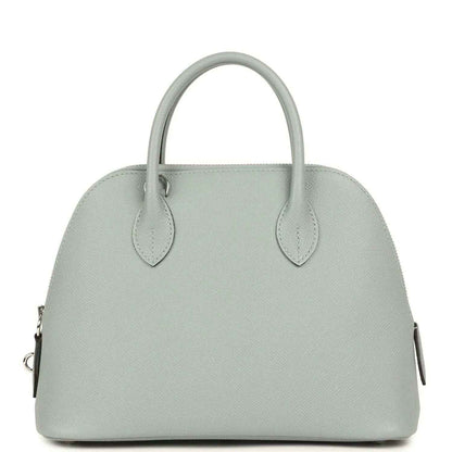 Light gray leather handbag front with two top handles and silver-tone hardware accents