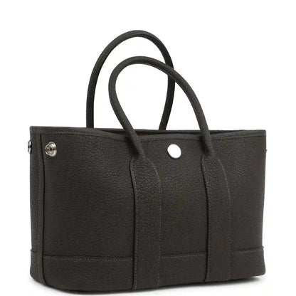 Leather tote bag with top handles, front panel pockets and small metal snap