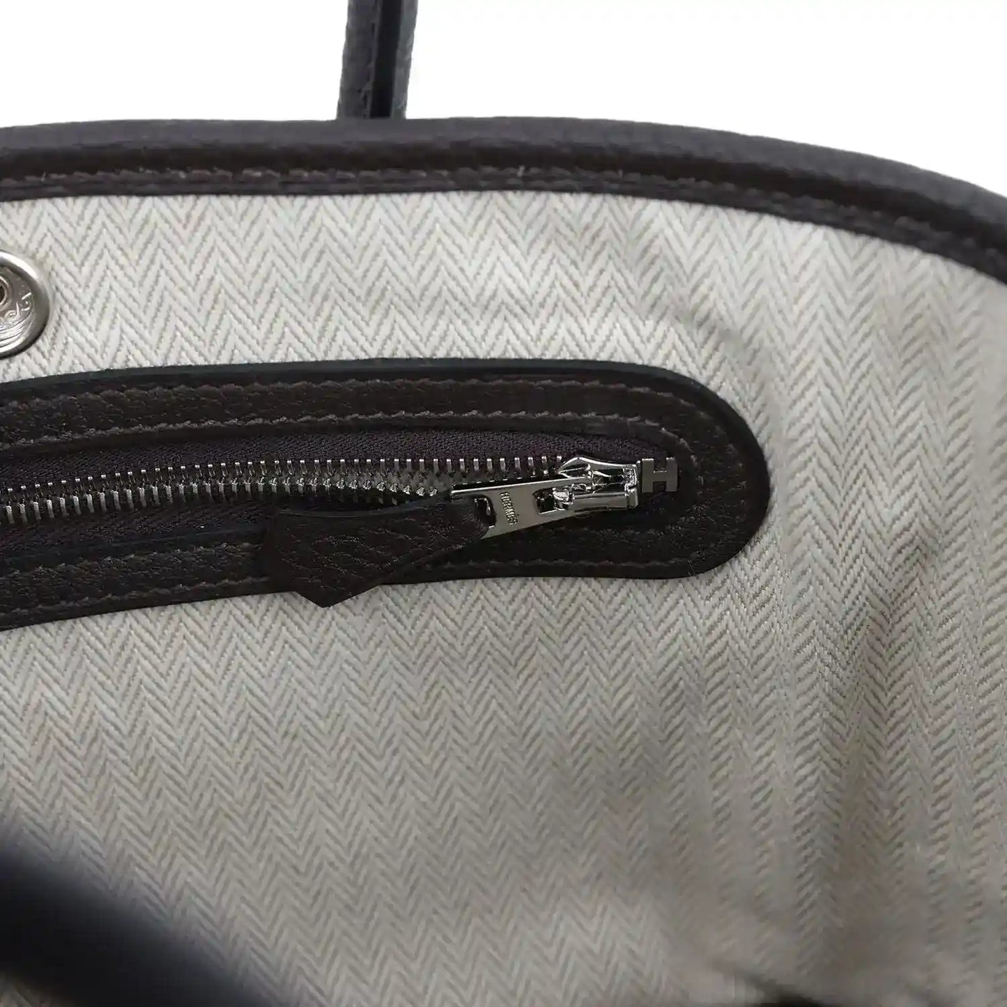 Leather zip pocket detail with silver-tone zipper pull and H logo on lining