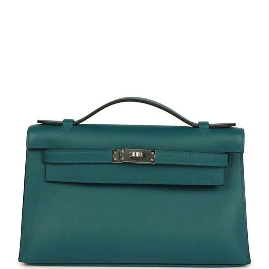 Teal green leather top-handle bag with front flap and silver-toned clasp hardware.