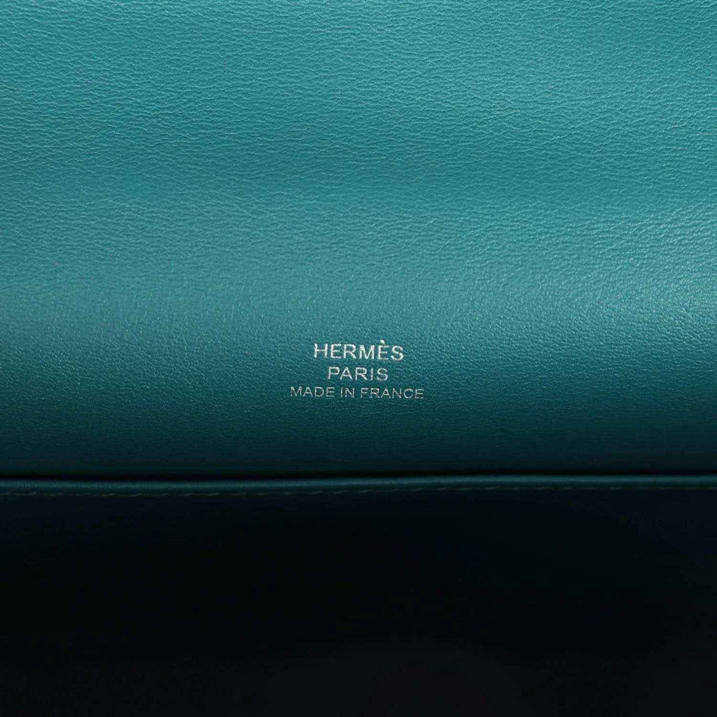 Teal green leather stamp panel reading HERMÈS PARIS MADE IN FRANCE.
