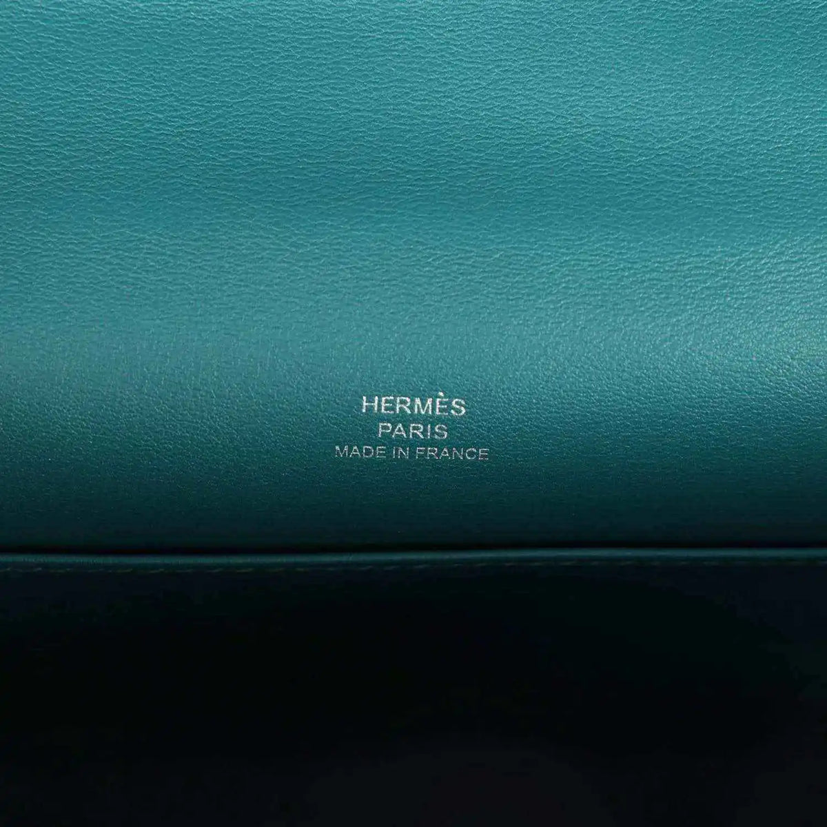 Teal green leather stamp panel reading HERMÈS PARIS MADE IN FRANCE.