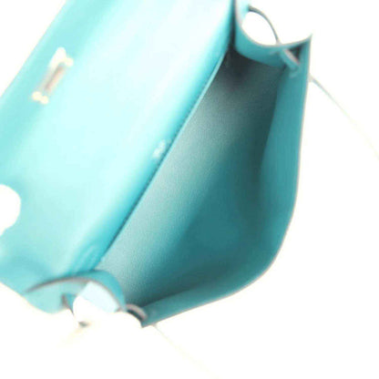 Teal green leather bag interior corner with smooth lining and stitched seam, close-up.