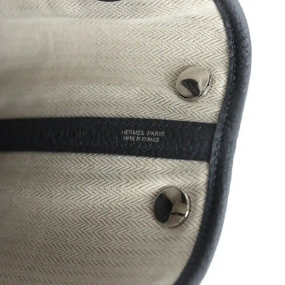 Cream fabric lining with dark trim, round hardware, and Hermes Paris label