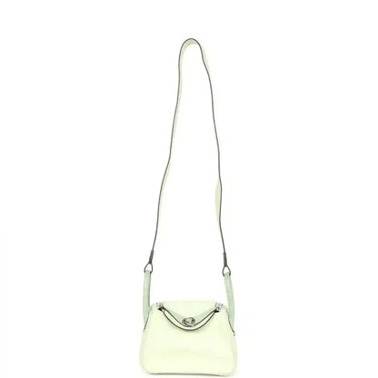 Mini Lindy mini bag on long strap, pale green leather with curved front clasp