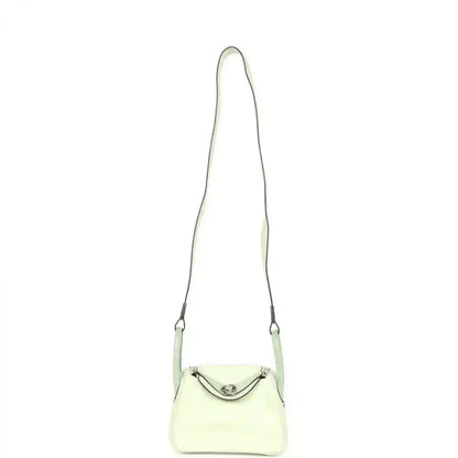 Mini Lindy mini bag on long strap, pale green leather with curved front clasp