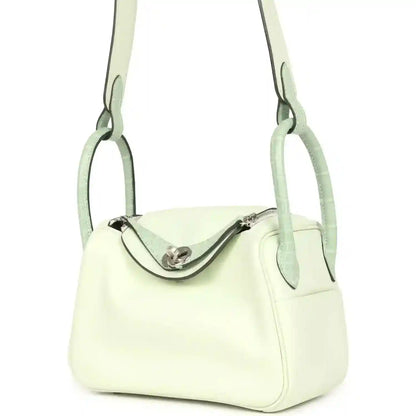 Mini Lindy bag front view in pale green leather, curved clasp and short handles
