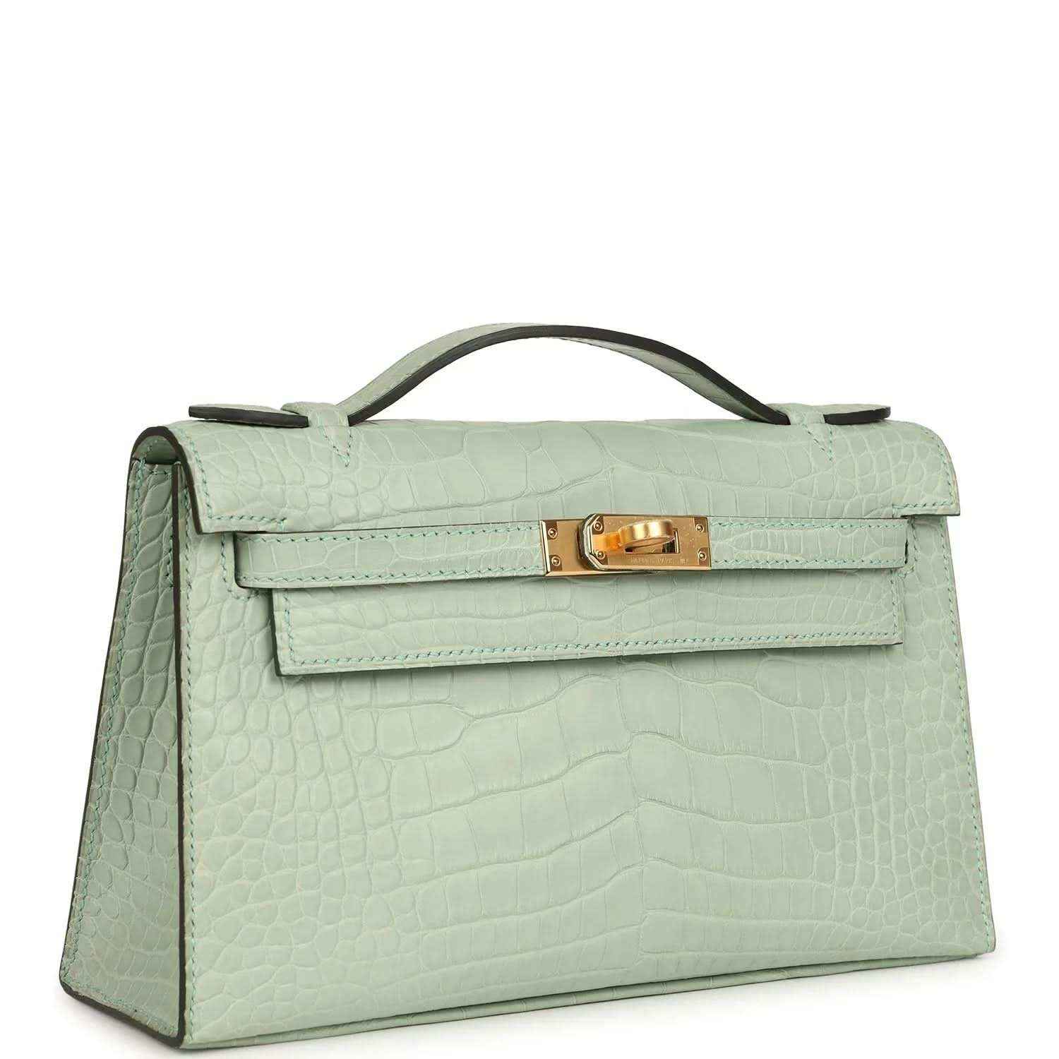 Mint green alligator-style pochette with flap, top handle, and gold clasp—angled view