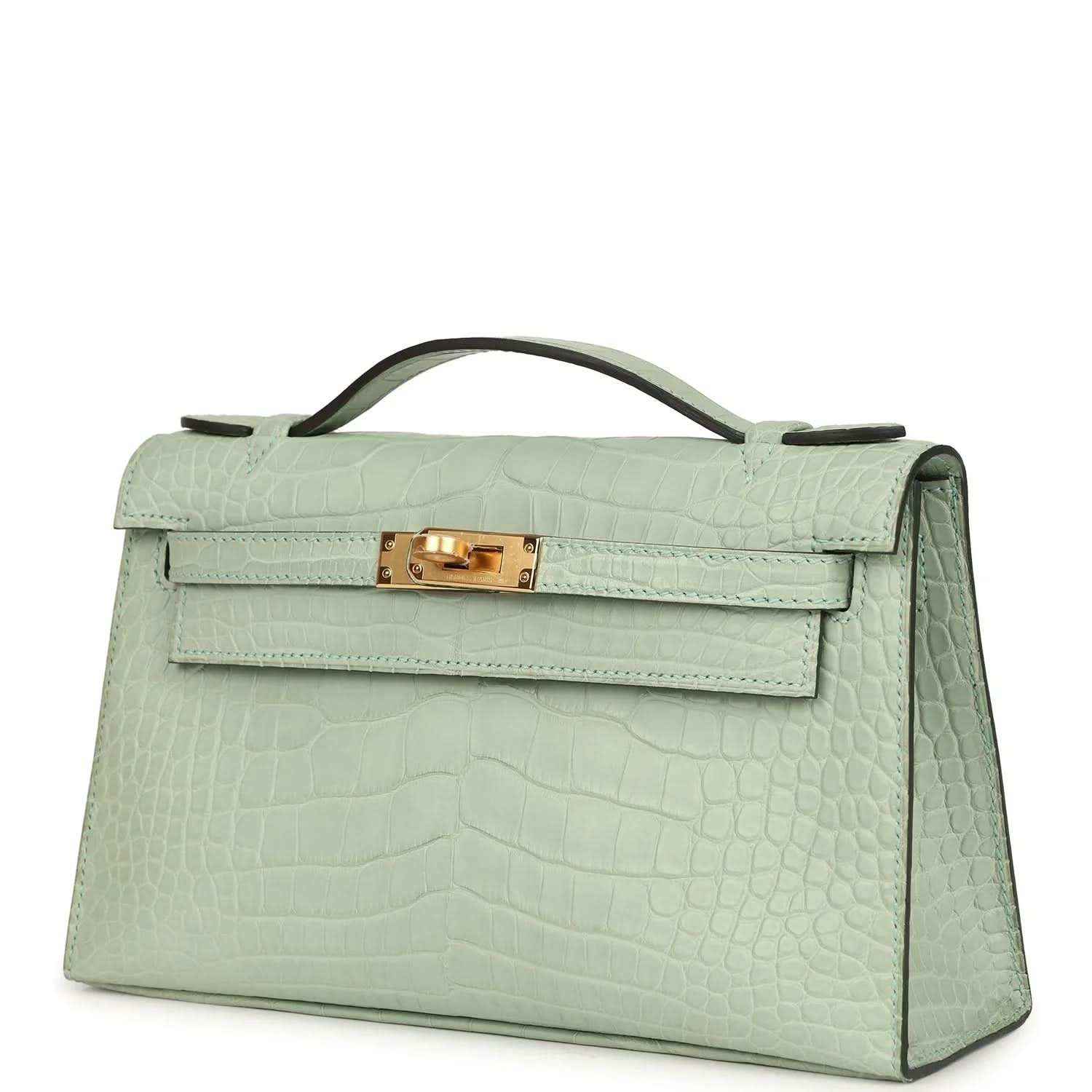 Mint green alligator-style pochette side profile with gold front clasp and handle