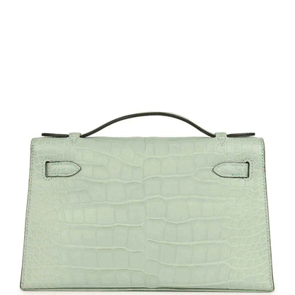 Mint green alligator-style pochette back with two stitched flap tabs