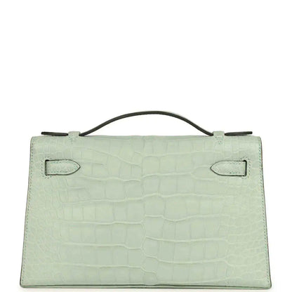 Mint green alligator-style pochette back with two stitched flap tabs