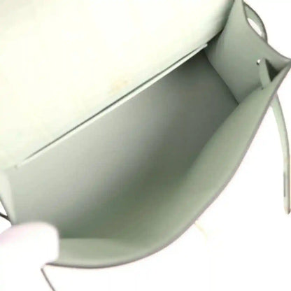 Mint green interior of alligator-style pochette with smooth lining and edge seam