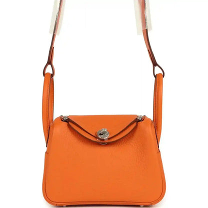 Orange clemence leather mini shoulder bag with flap closure and palladium-tone hardware.