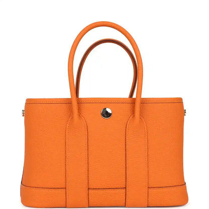 Orange leather tote bag with central divider and snap button hardware