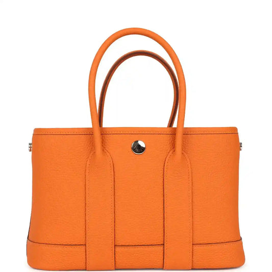 Orange leather tote bag with central divider and snap button hardware