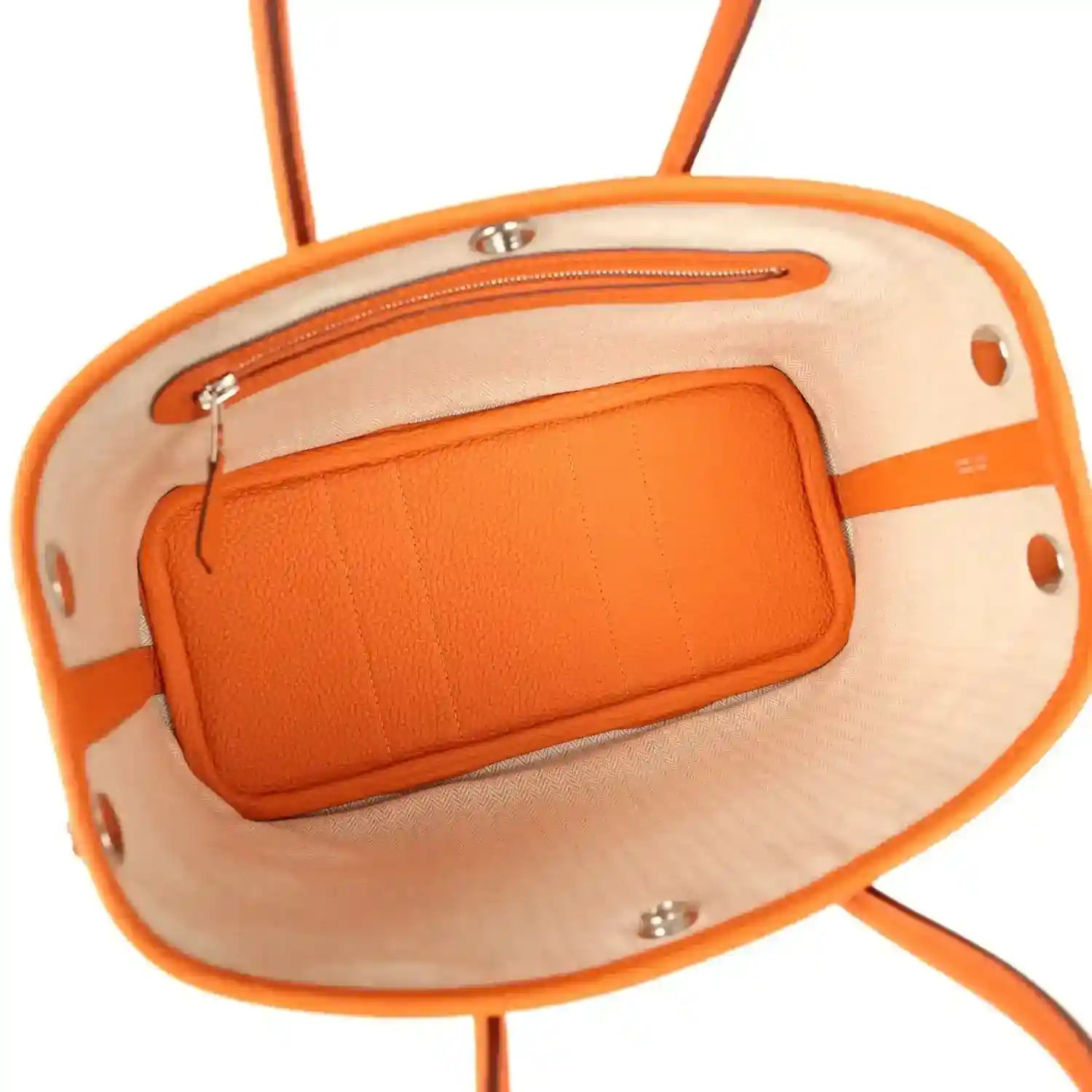 Orange leather-lined interior pocket with silver hardware inside tote bag